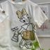 Blusa Infantil Animê Off White Minnie Dourada Frente Verso Margarida Aplicação Laço Dourado Strass