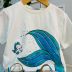 Conjunto Infantil Momi Blusa Off White Pequena Sereia Saia Tule Azul Turquesa Glitter Holográfico