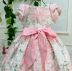 Vestido Infantil de Festa Petit Cherie Rosas Brancas Sobrep. Tule Lacinhos Manga Bufante Cinto Rosa